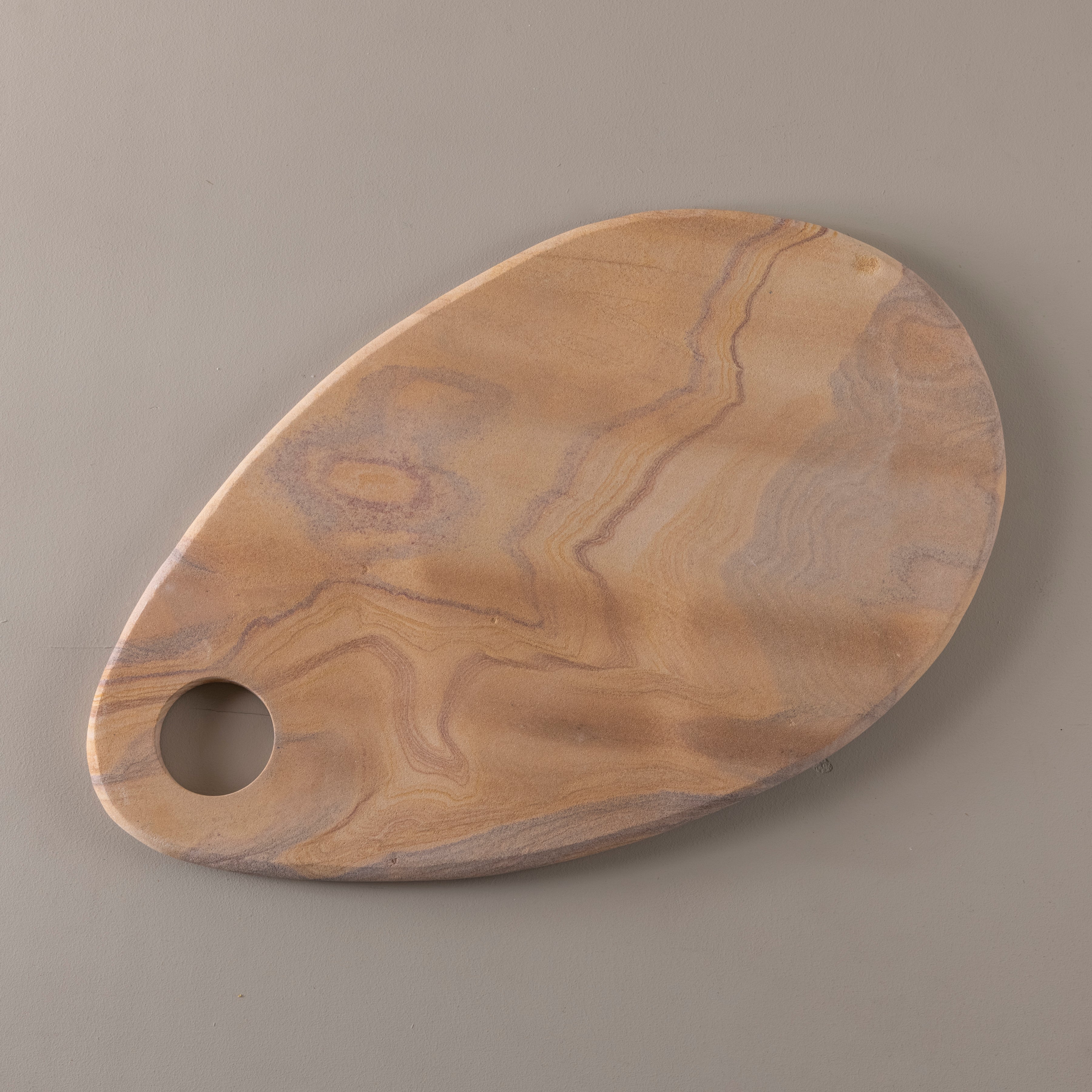 Wooden cutting board with a hole on a gray background