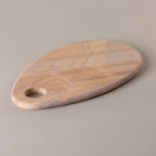 Wooden cutting board with a handle on a gray background