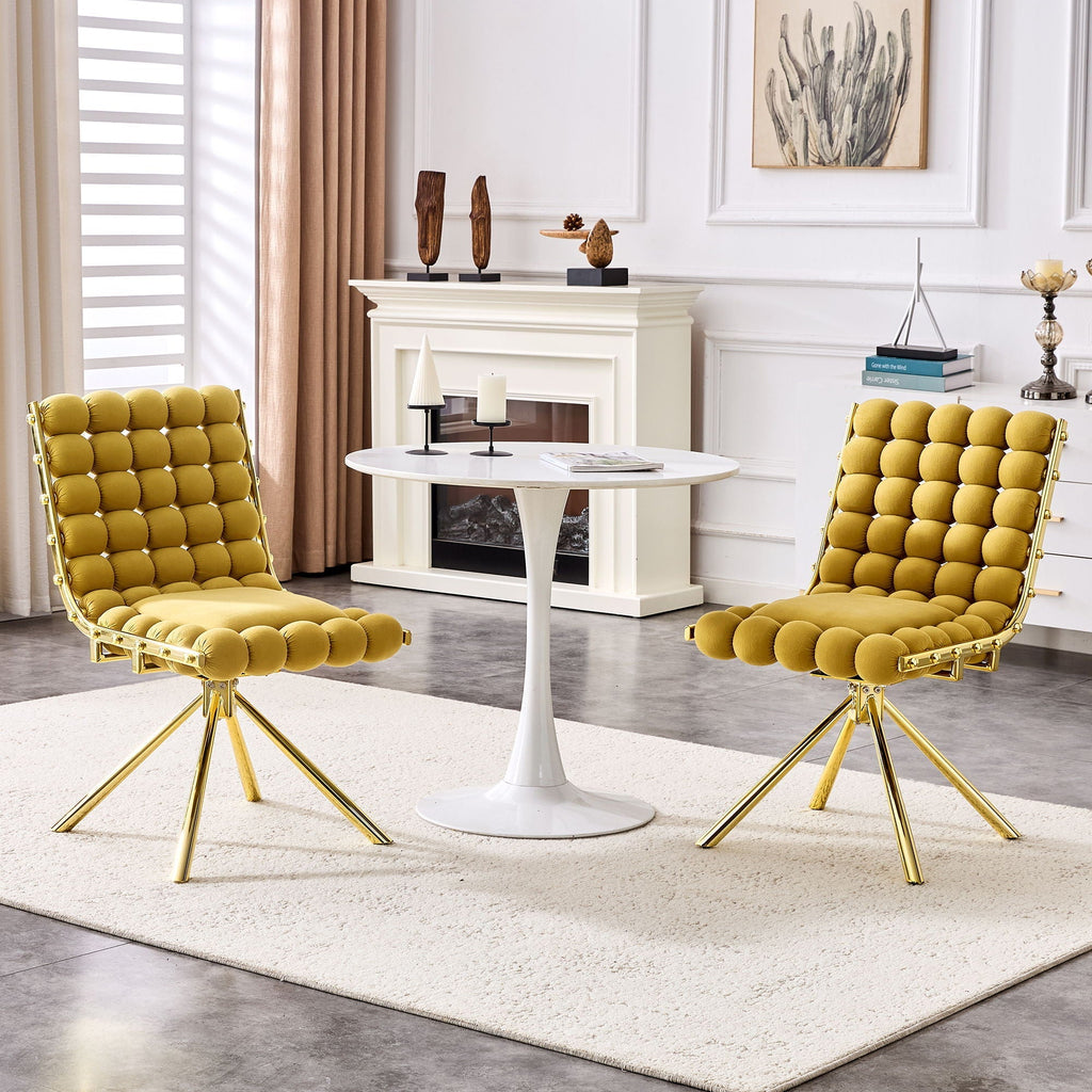 Two yellow chairs with gold legs in a living room setting.