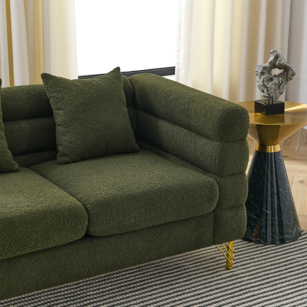 Green sofa in a room with a table and decorative object.
