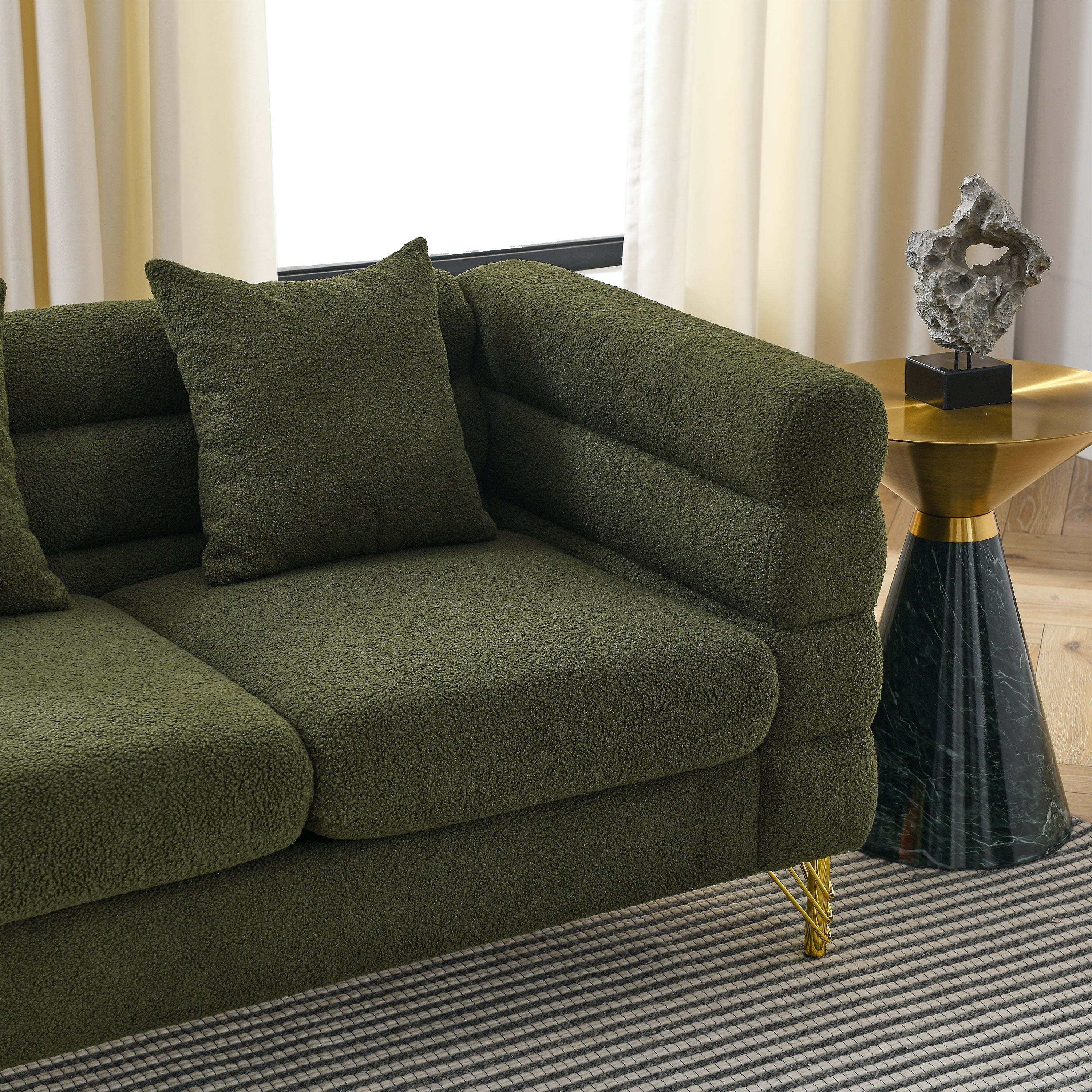 Green sofa in a room with a table and decorative object.