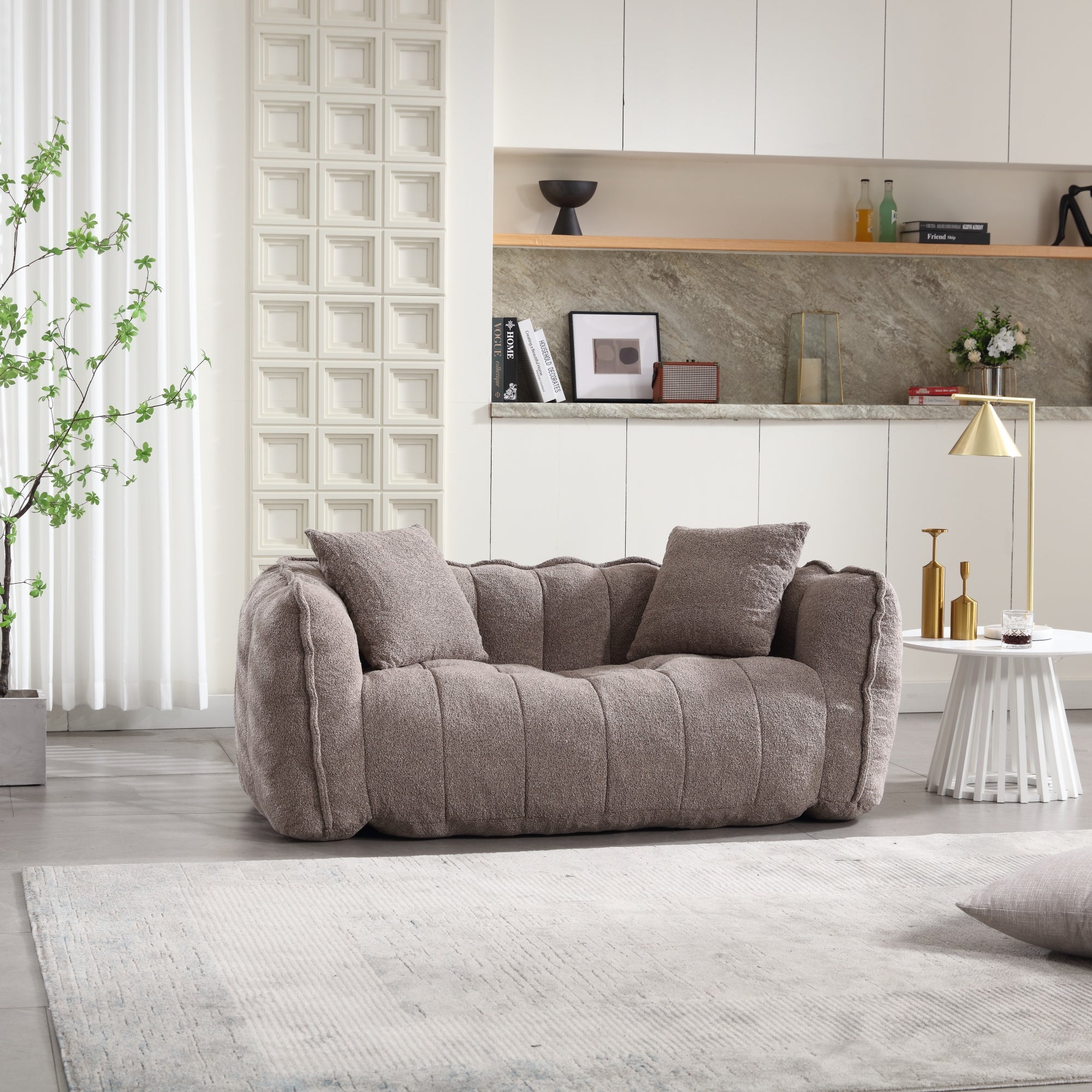 Gray sofa in a modern living room with a kitchen in the background