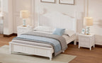 White bedroom set with bed, nightstands, and lamps in a well-lit room.