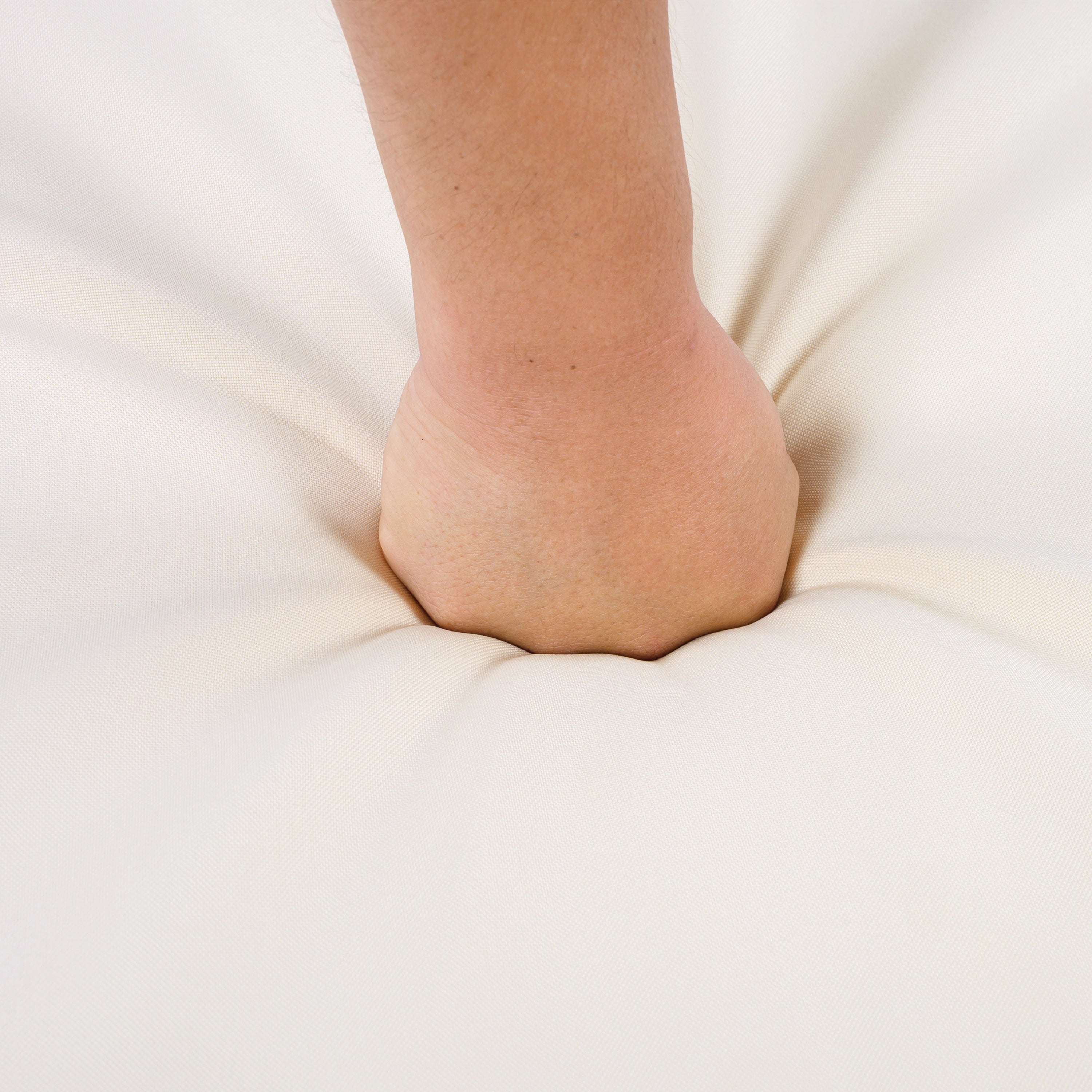 Foot resting on a white cushion