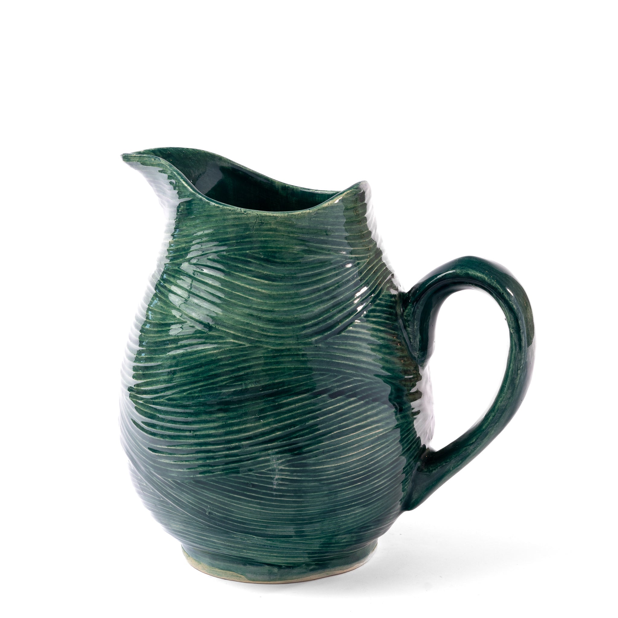 Green ceramic pitcher with textured surface on a white background