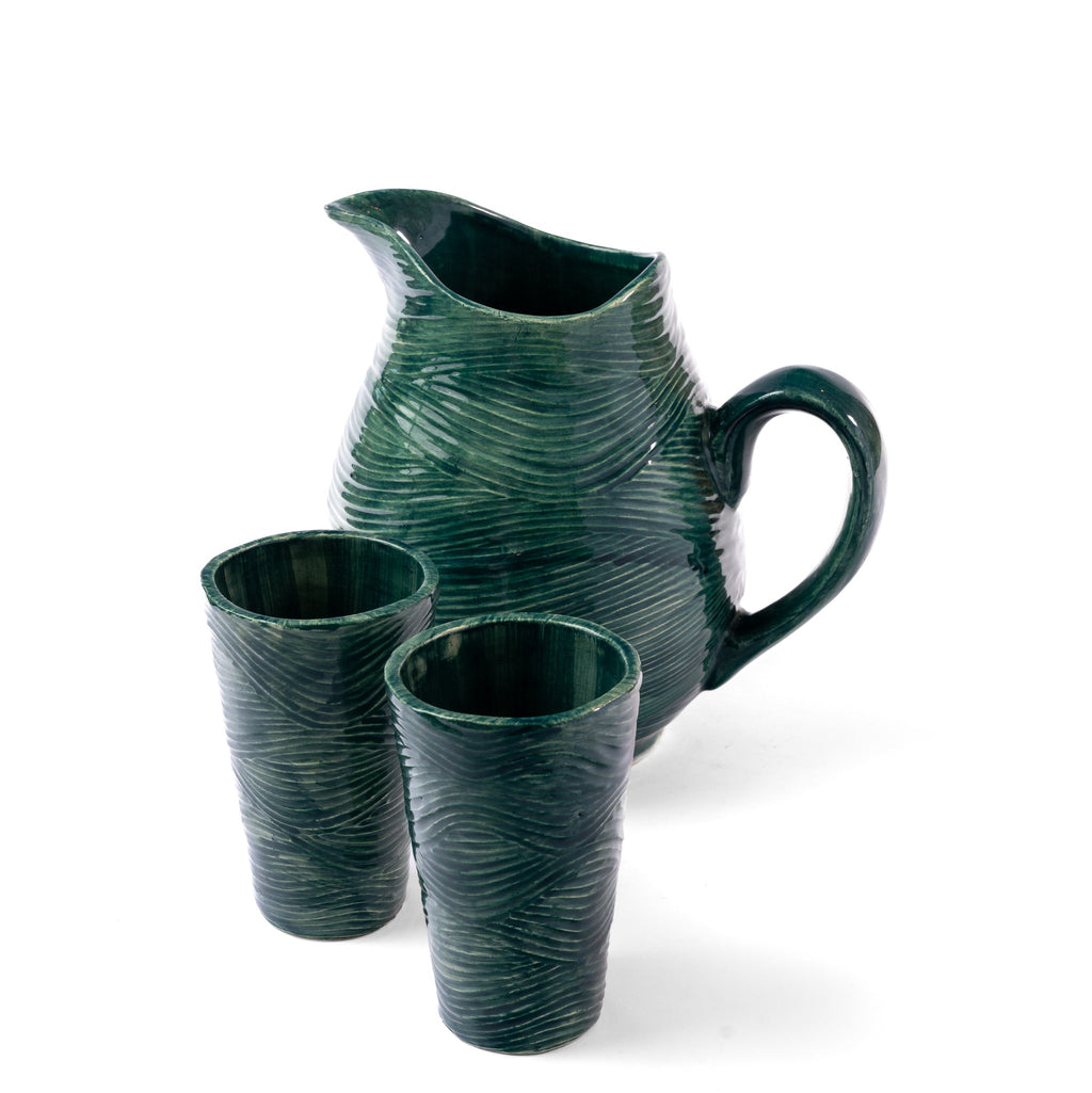 Green ceramic pitcher and two cups on a white background