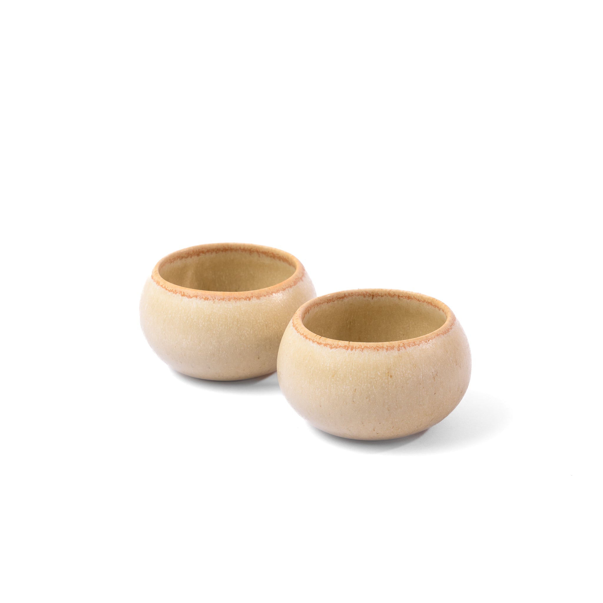 Two beige ceramic bowls on a white background