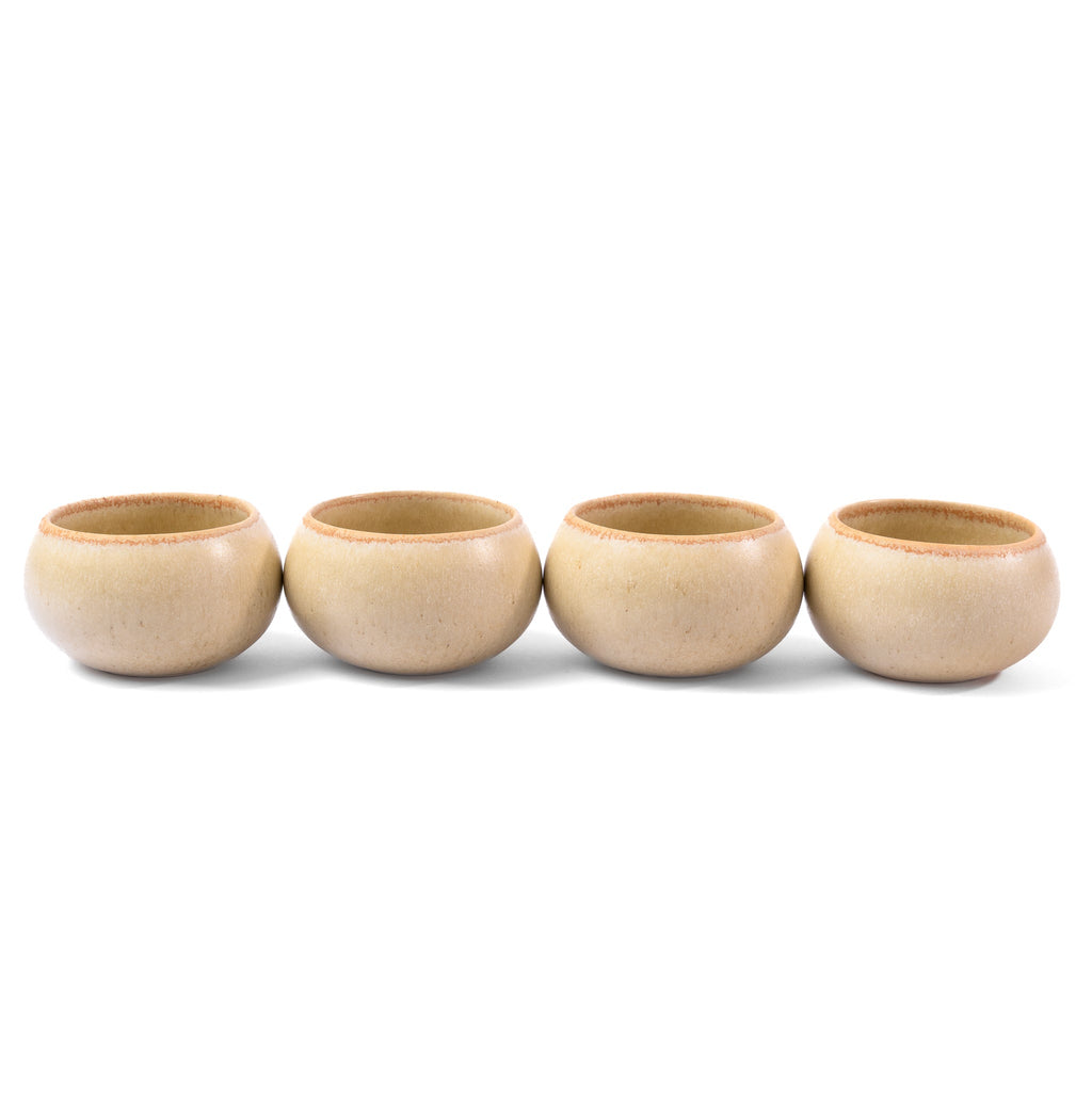 Four beige ceramic cups arranged in a row on a white background