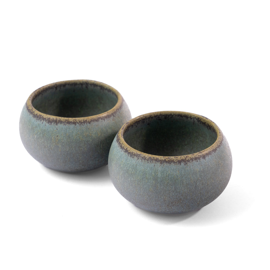 Two ceramic bowls with a dark blue glaze on a white background