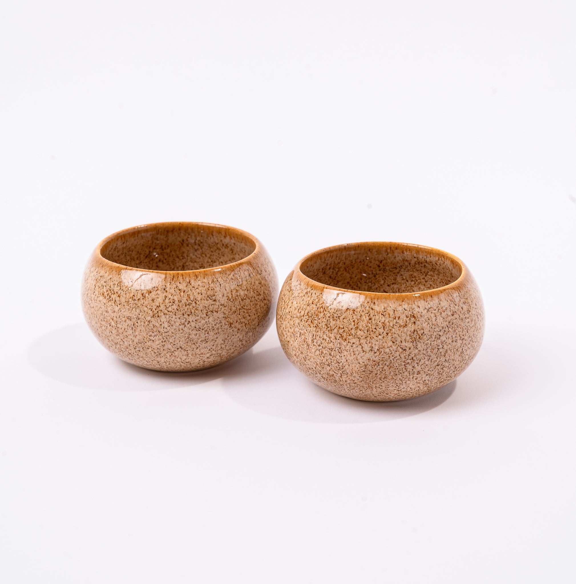 Two ceramic bowls with a speckled finish on a white background
