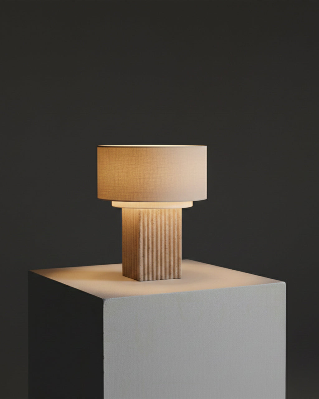 Table lamp with textured base and beige shade on a dark background