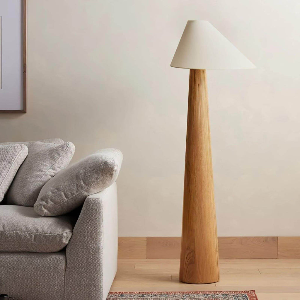 Wooden floor lamp next to a gray sofa in a living room setting.