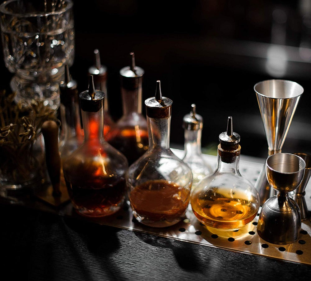 Bottles of alcohol on a bar tray with a dark background