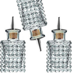 Set of three crystal glass bottles with diamond pattern on a white background
