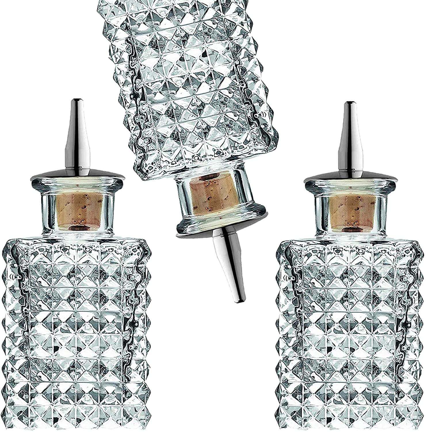 Set of three crystal glass bottles with diamond pattern on a white background