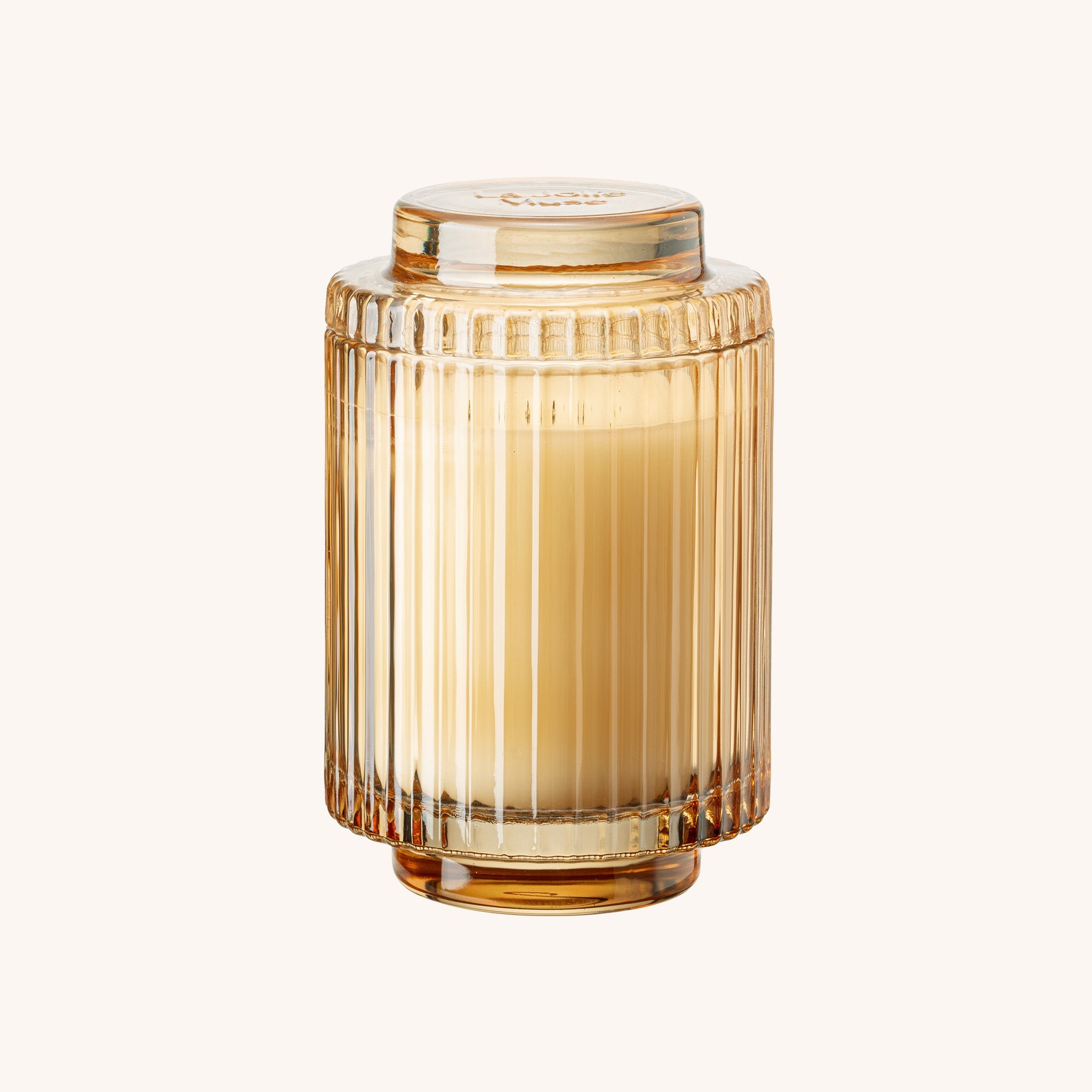 Gold ribbed glass jar with a lid on a white background