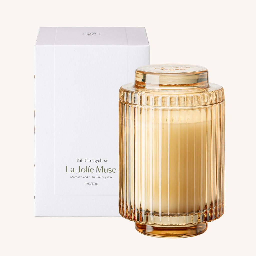 Glass candle with ribbed design and 'La Jolie Muse' branding on a white background