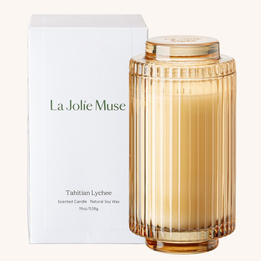 Scented candle with ribbed design and 'La Jolie Muse' packaging on a white background
