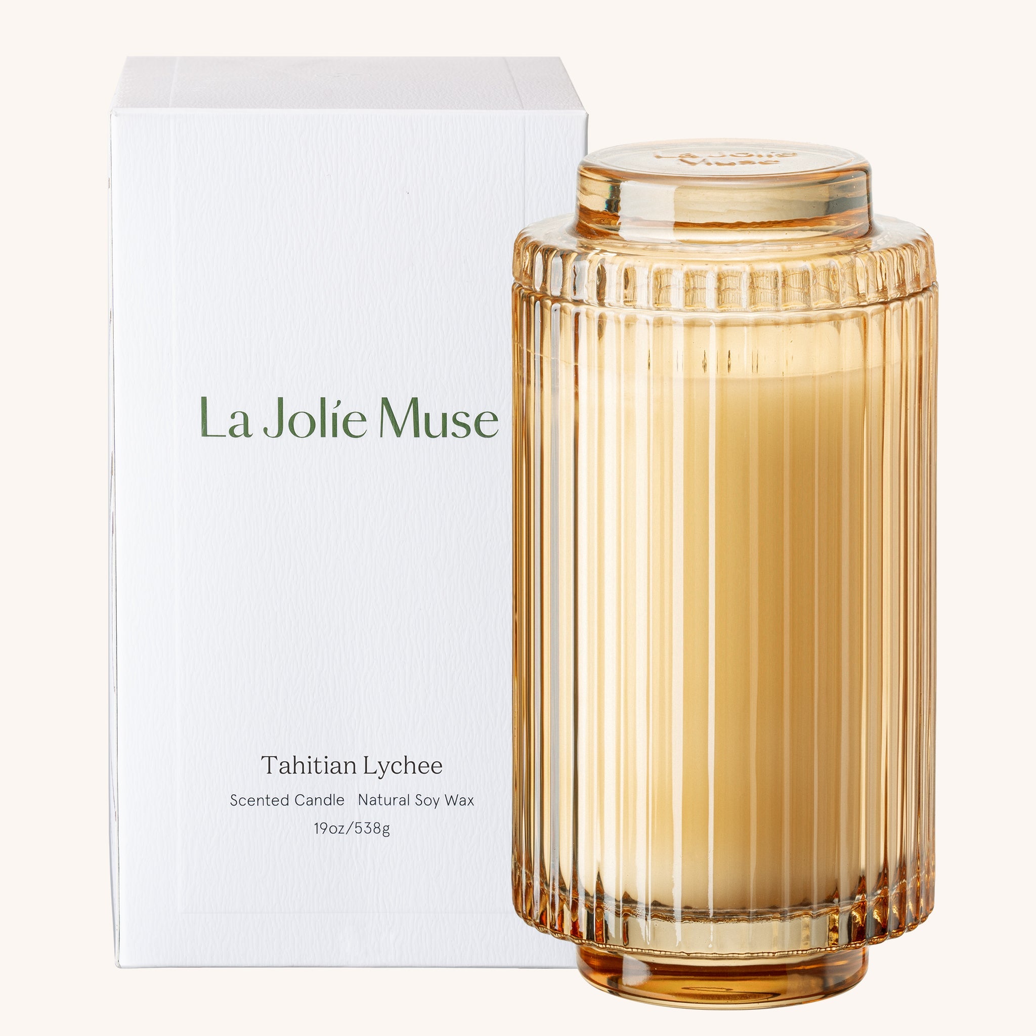 Scented candle with ribbed design and 'La Jolie Muse' packaging on a white background