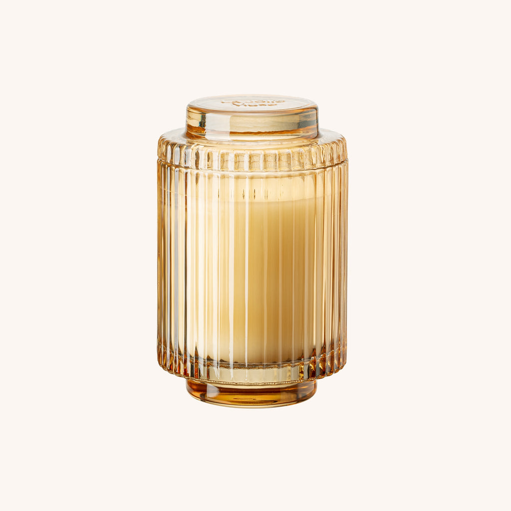 Gold glass vase with ribbed design on a white background