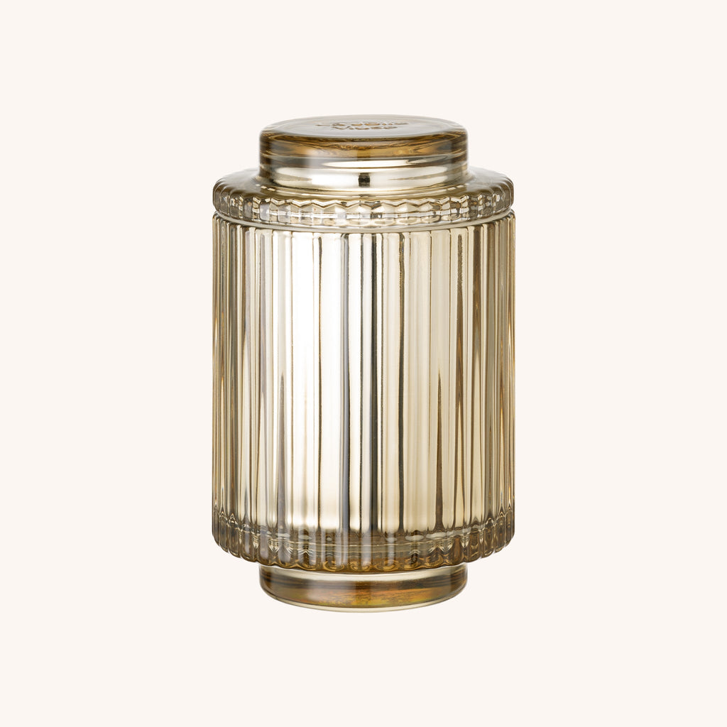 Decorative glass candle jar with ribbed design on a white background