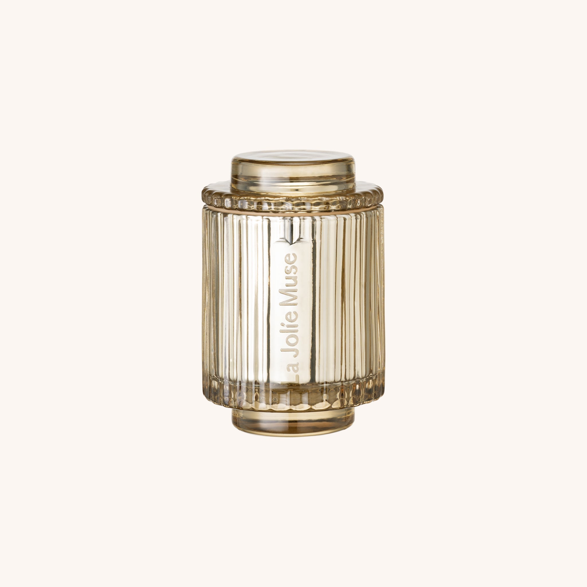Decorative candle with 'La Jolie Muse' branding on a white background