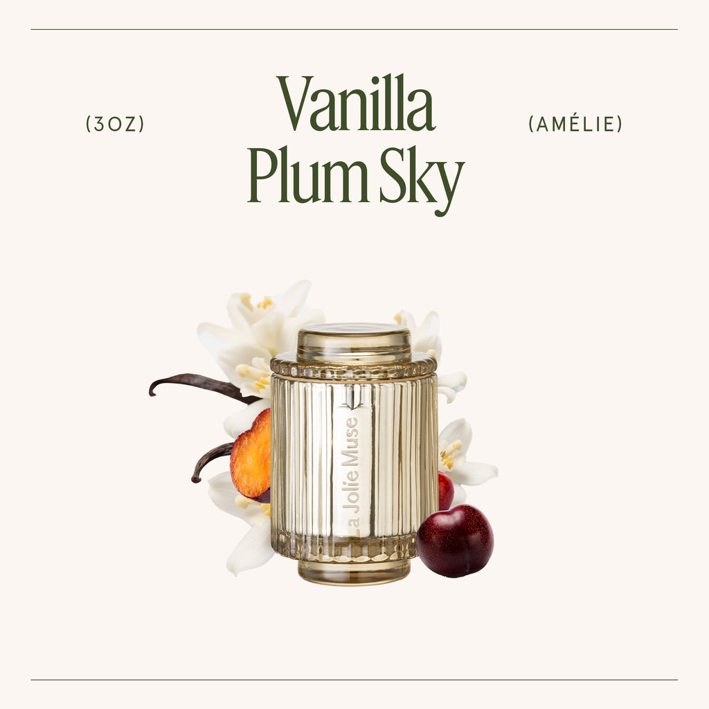 Vanilla Plum Sky candle bottle with vanilla bean, plum, and flower elements on a white background