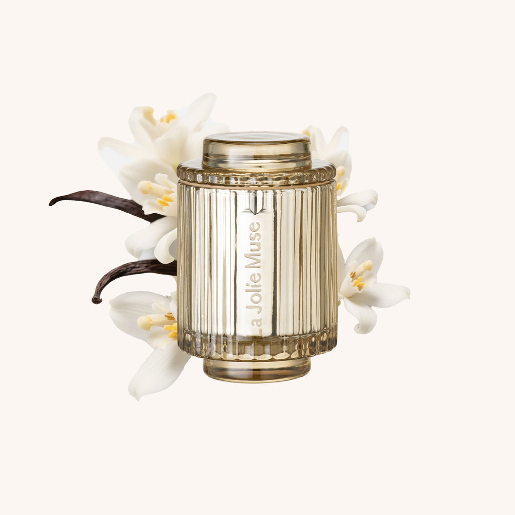 Decorative candle with vanilla bean and flowers on a white background