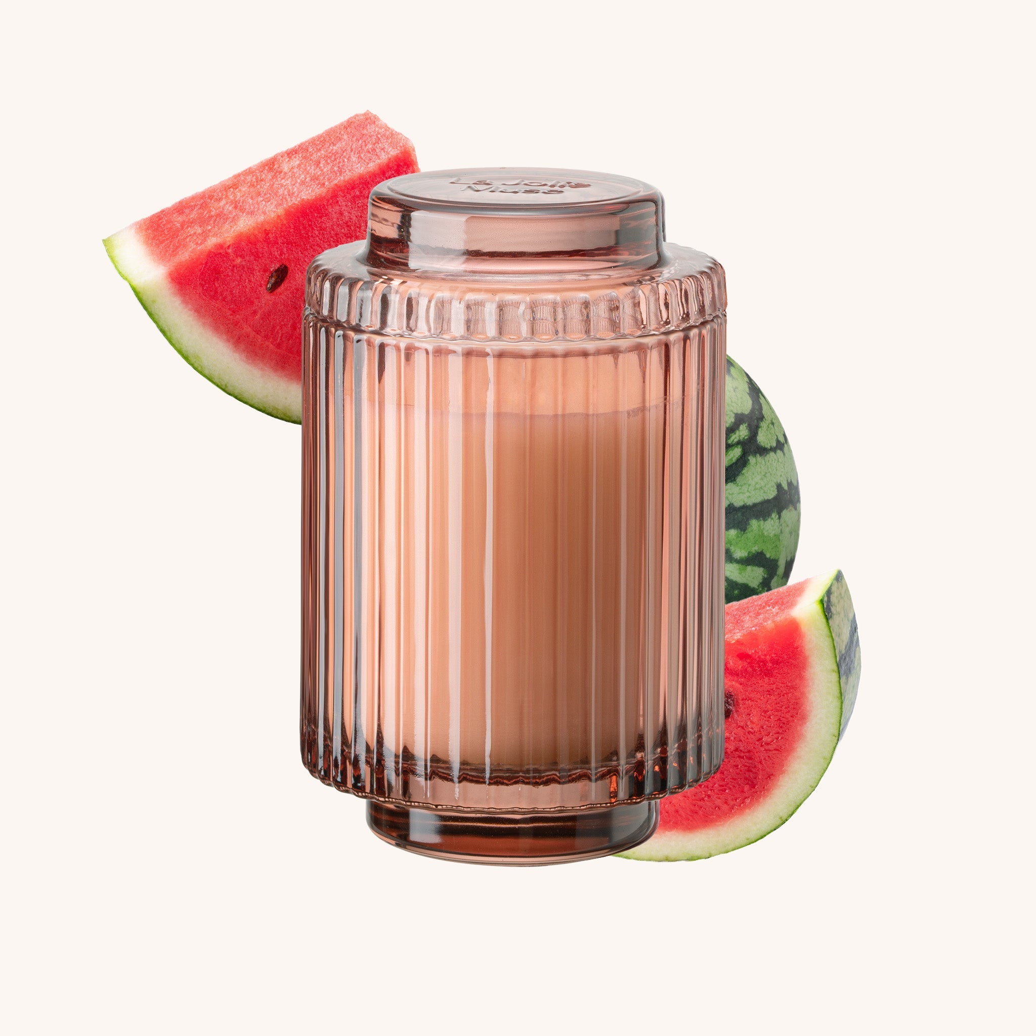 Cylindrical glass container with ribbed design surrounded by watermelon slices on a white background
