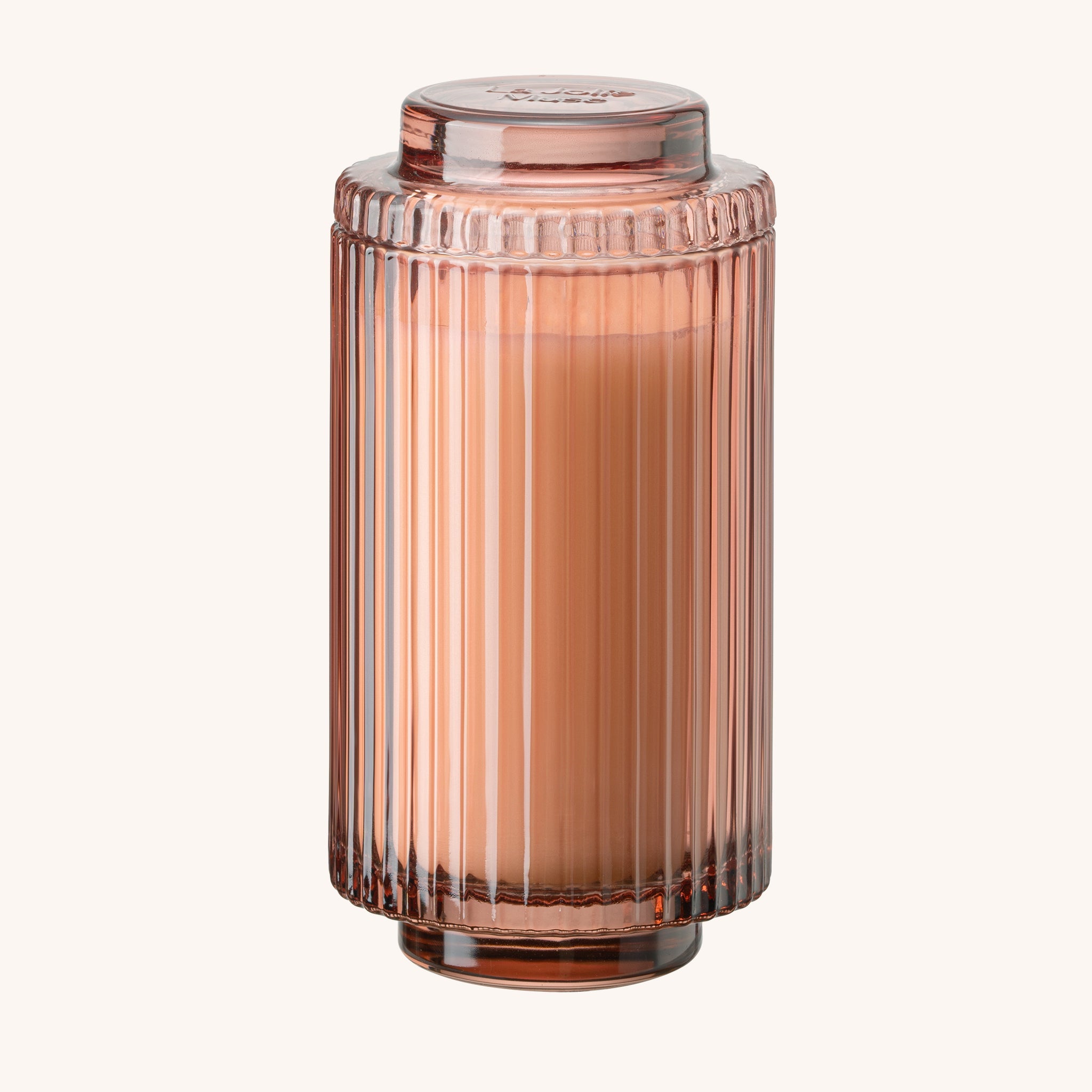 Rose gold ribbed candle jar on a white background