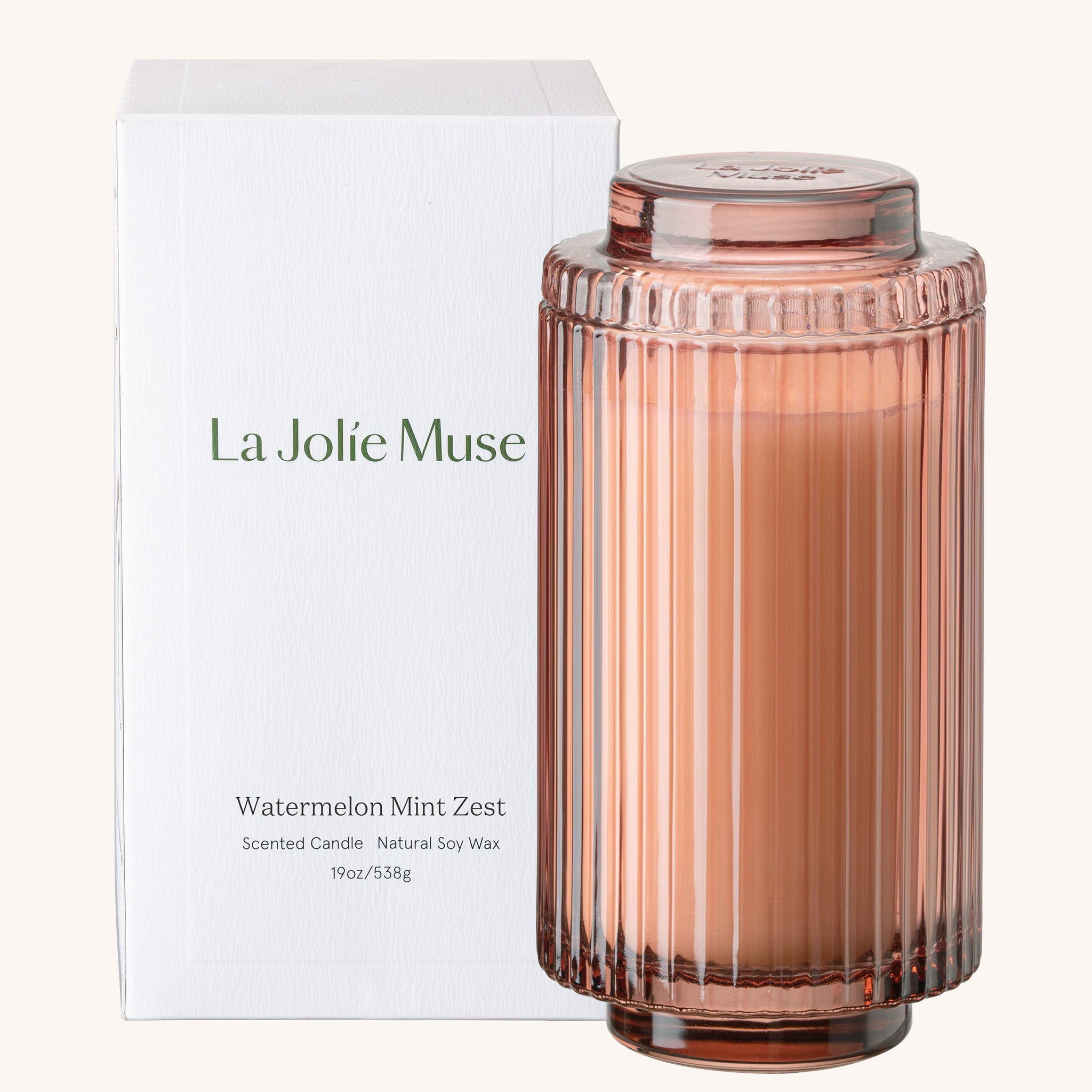 Candle with ribbed design and 'La Jolie Muse' branding on a white background