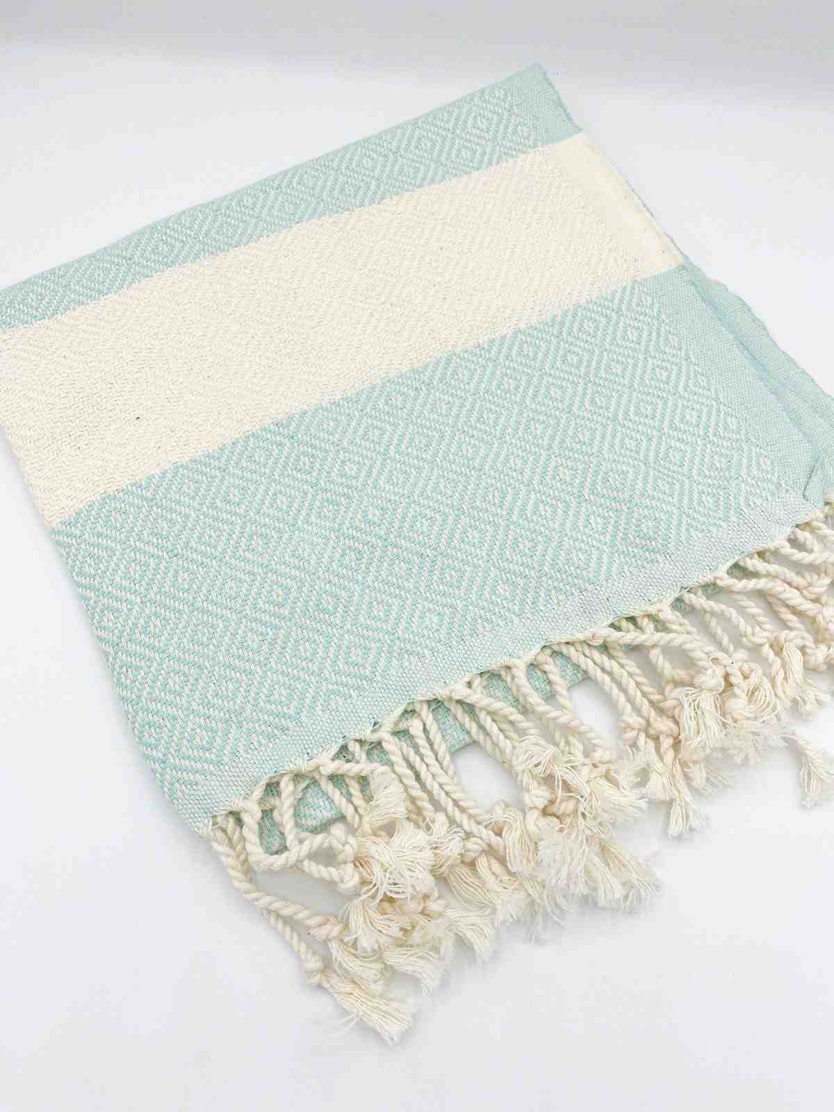 Aqua diamond-pattern hand towel with cream stripe and fringe, laid on white background