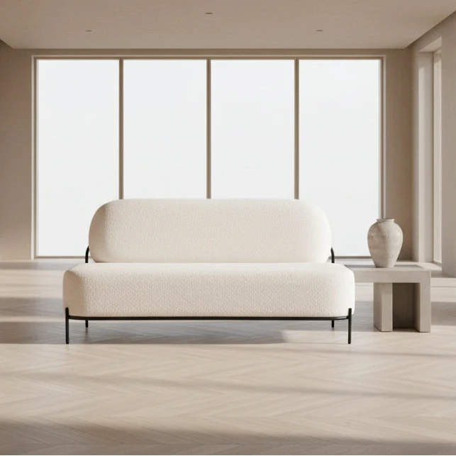 Modern white sofa in a minimalistic room with large windows.
