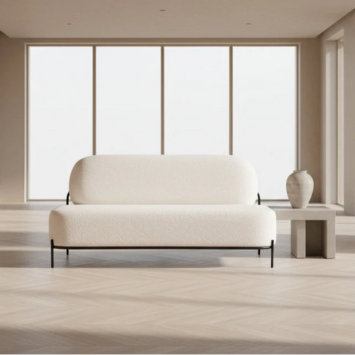 Modern white sofa in a minimalistic room with large windows.