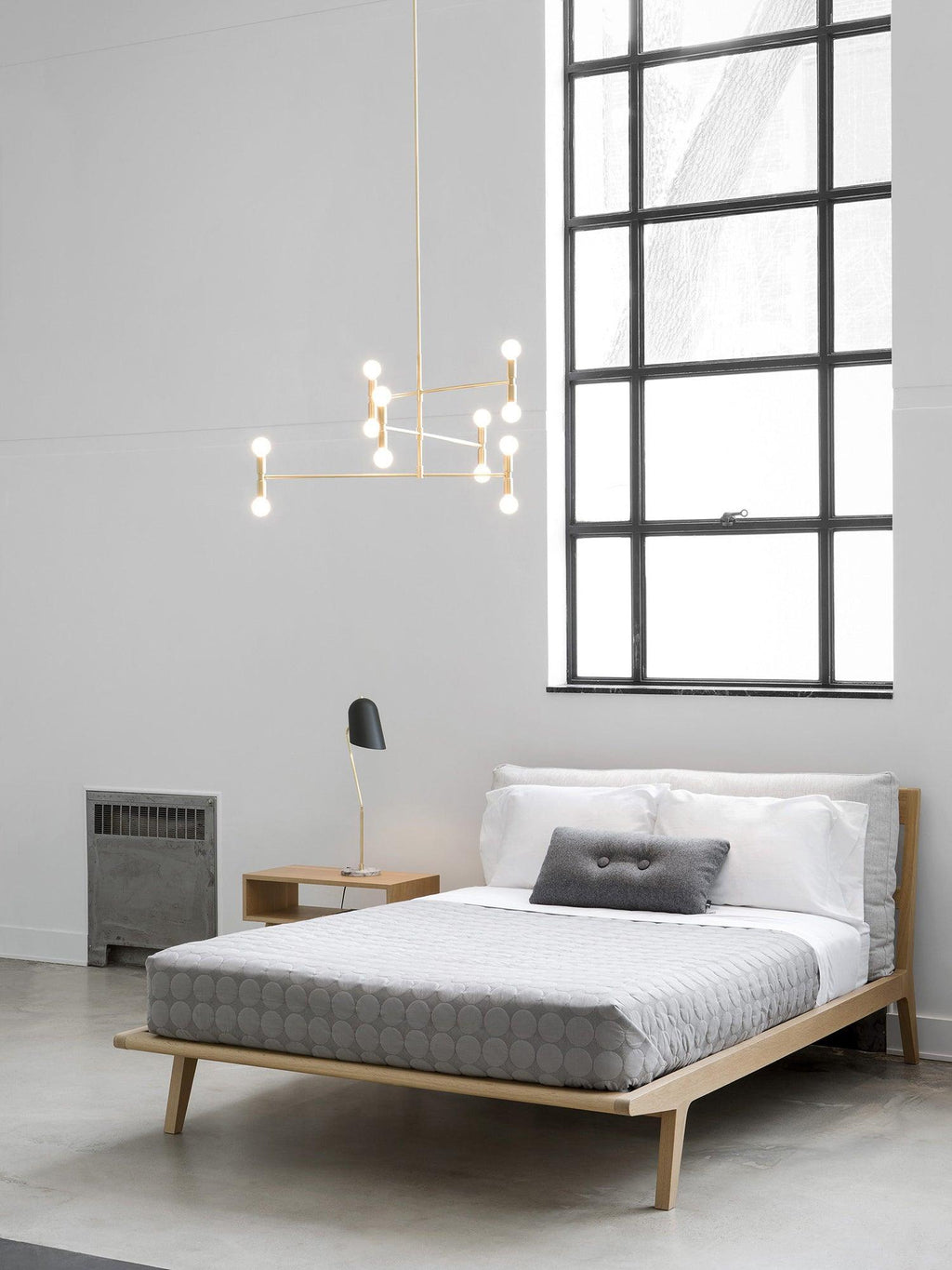 Modern bedroom with a bed, nightstands, and a large window.