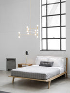 Modern bedroom with a bed, nightstands, and a large window.