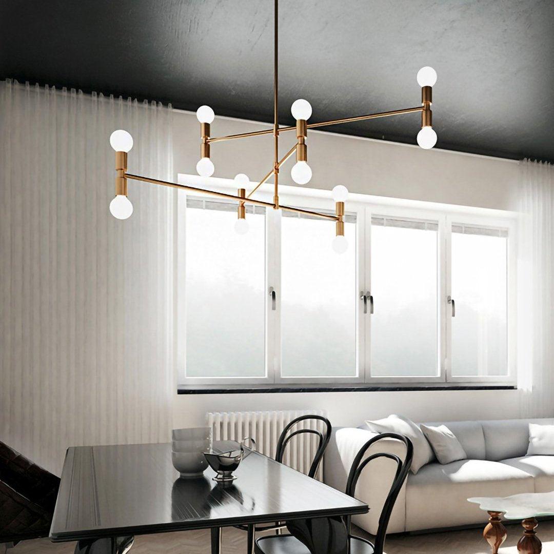 Modern chandelier hanging in a living room with a table and sofa.