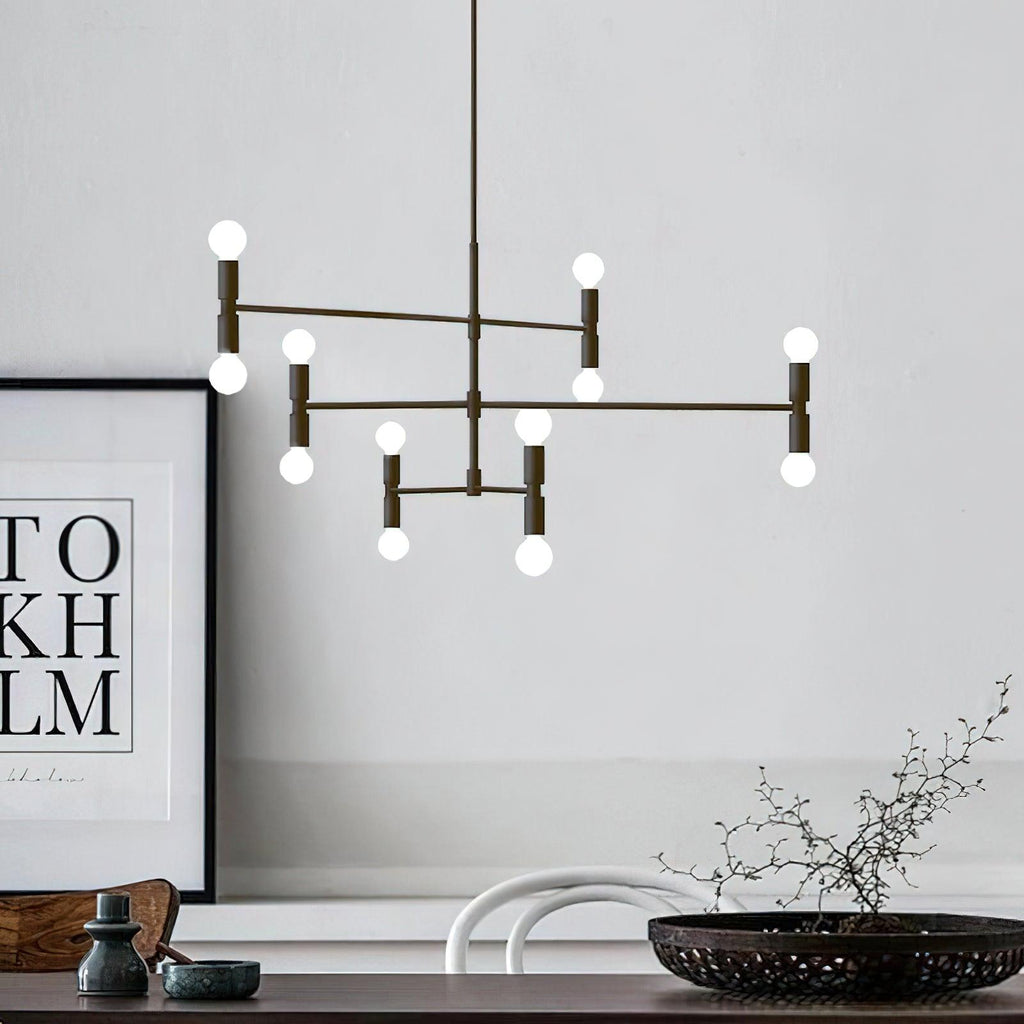 Modern chandelier hanging above a table with decor items in a room.