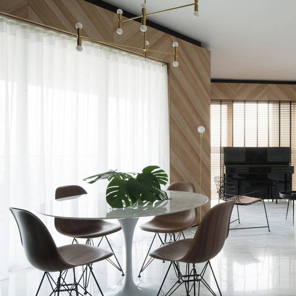 Modern dining area with a white table and brown chairs in a stylish room.