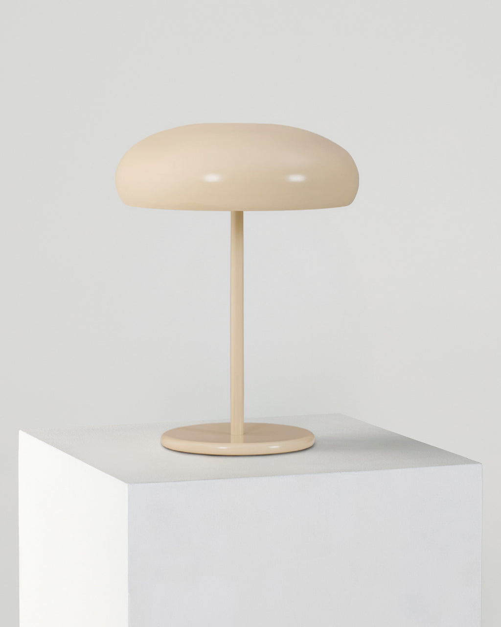Beige table lamp on a white surface with a light gray background