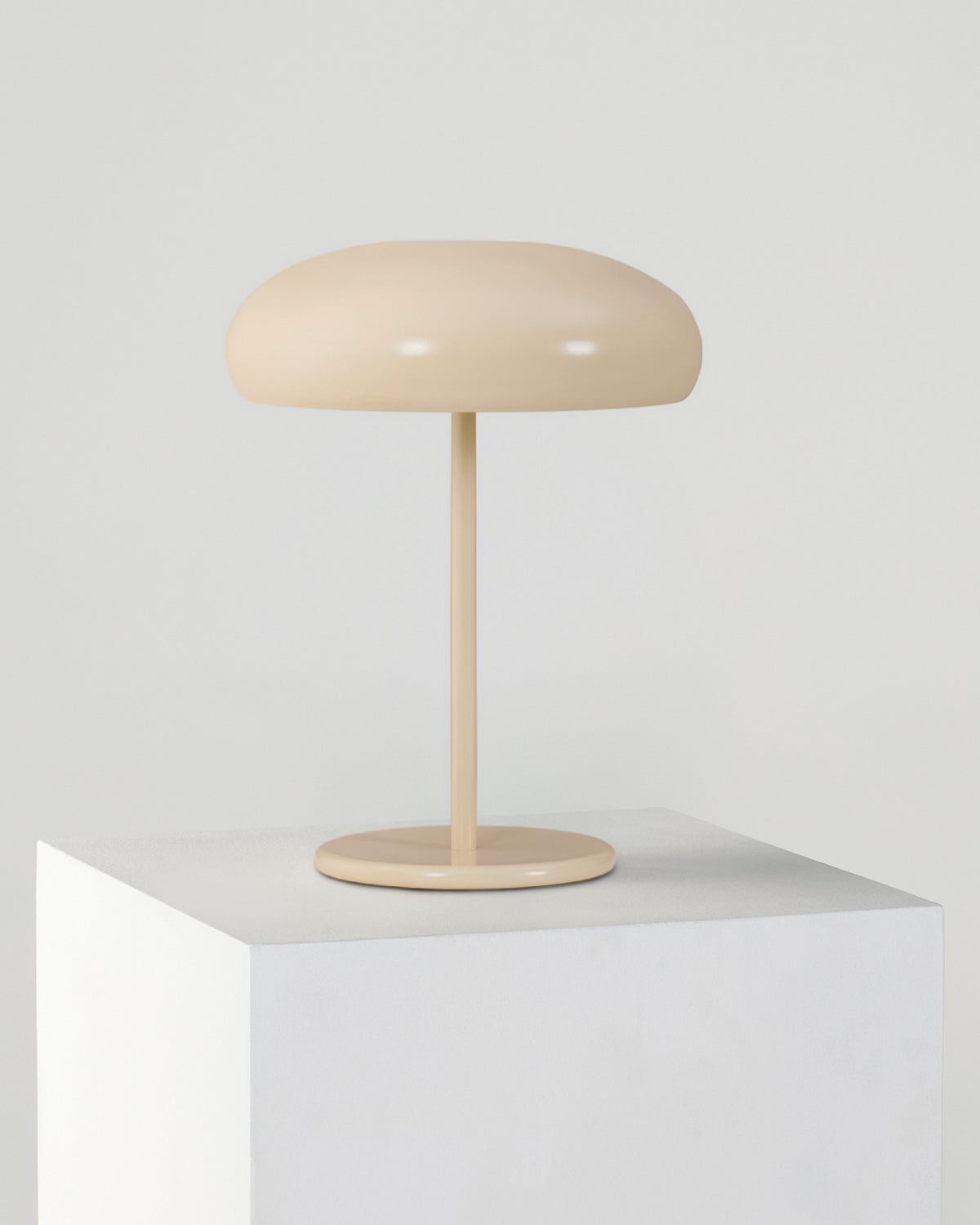 Beige table lamp on a white surface with a light gray background