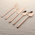 Rose gold cutlery set on a textured surface