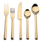 Set of gold cutlery including a knife, two forks, and two spoons on a white background.