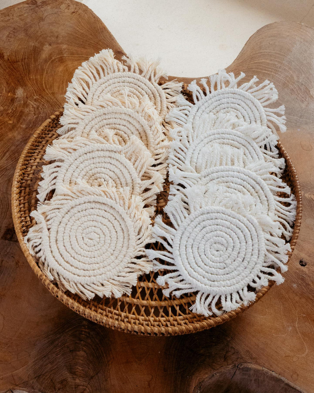 Set of white beaded coasters on a woven basket against a wooden background