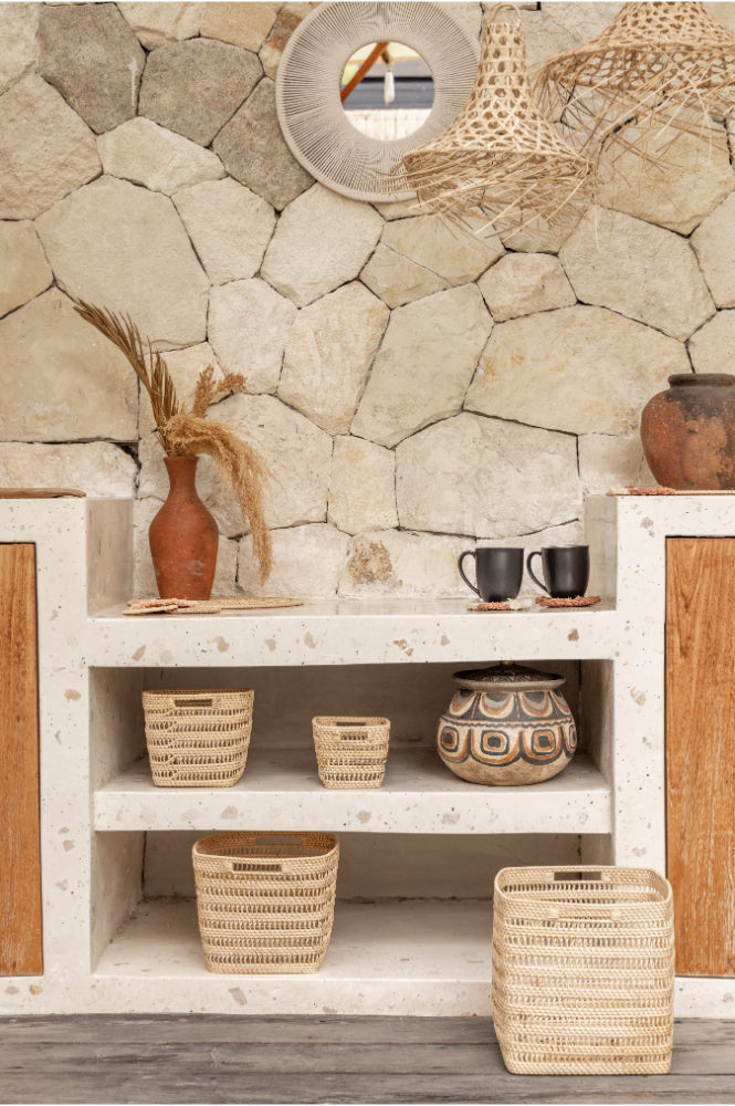 Niche with stone wall, wooden cabinets, and decorative items including vases and woven rattan baskets.