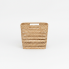 Woven storage rattan basket with handles on a white background