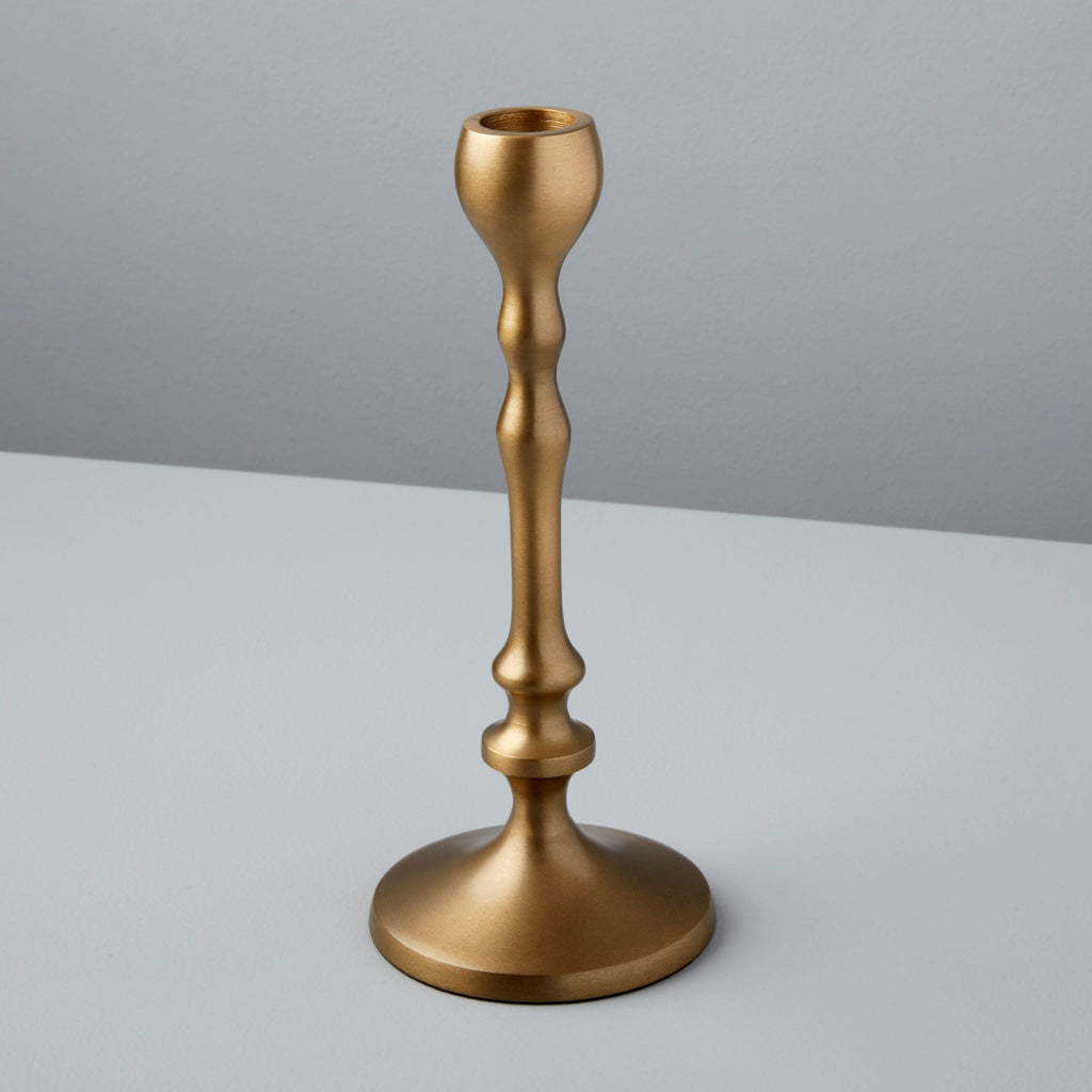 Gold candle holder on a gray background