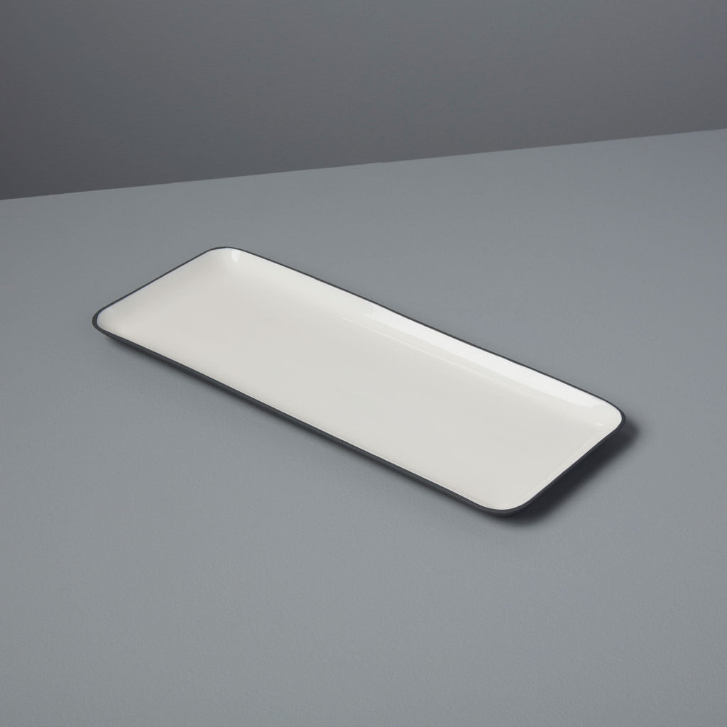 Rectangular white plate with black rim on a gray background
