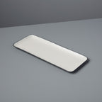 Rectangular white plate with black rim on a gray background