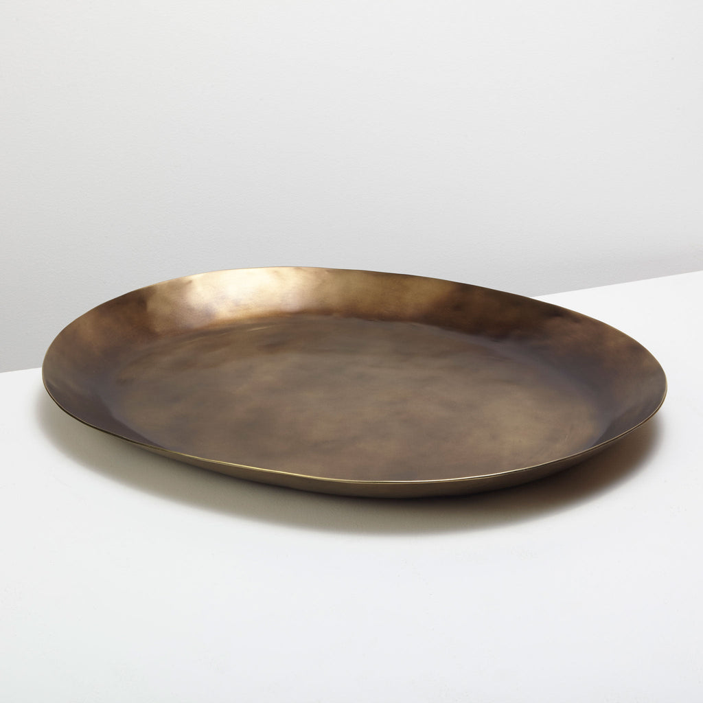 Bronze plate on a white surface with a light gray background